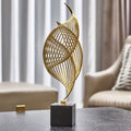 Sculture astratte dorate a forma di conchiglia