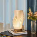 Lampada da tavolo con paralume a spirale e base in legno